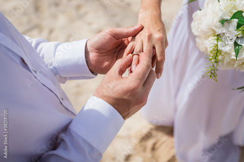 Fotografie Close up view of ring exchange at the wedding ceremony on the paradise beach, Pu