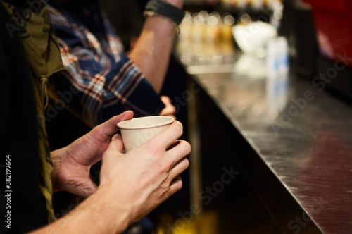 A man is holding a brown paper cup