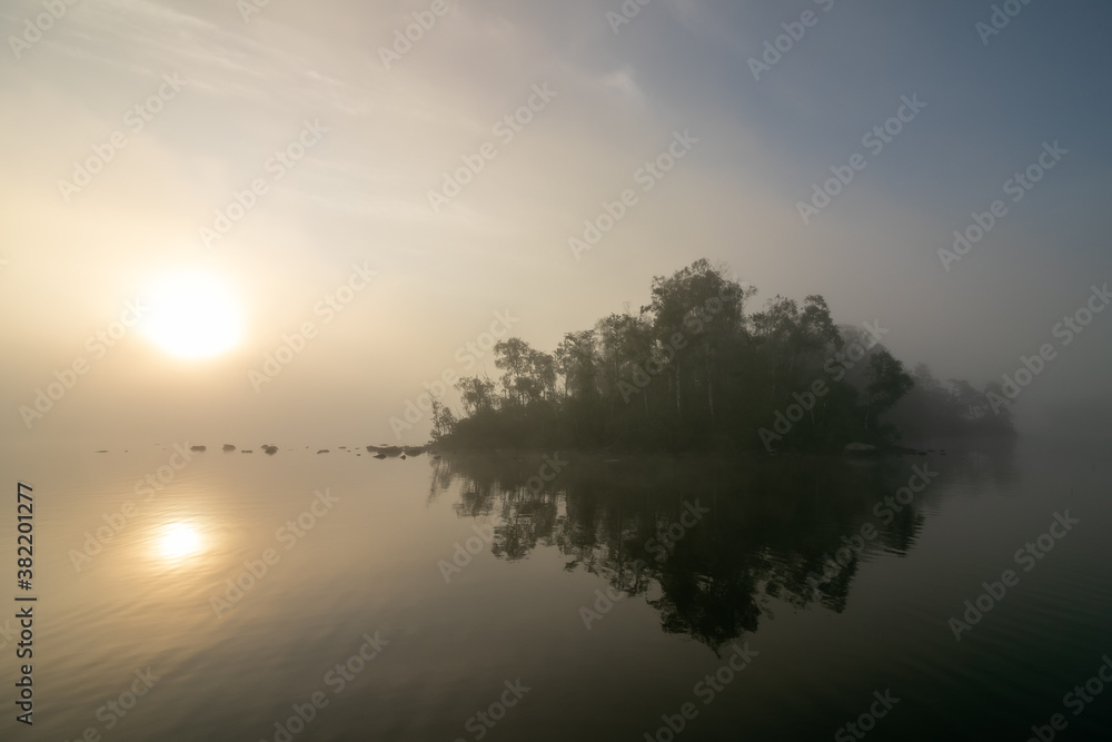 mysteische Lichtstimmung am See mit Nebel und Sonne
