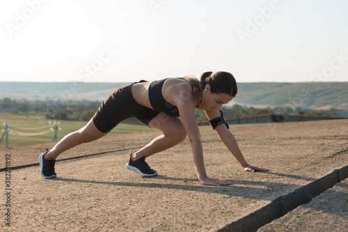 Young attractive woman doing exercise working out outdoors.