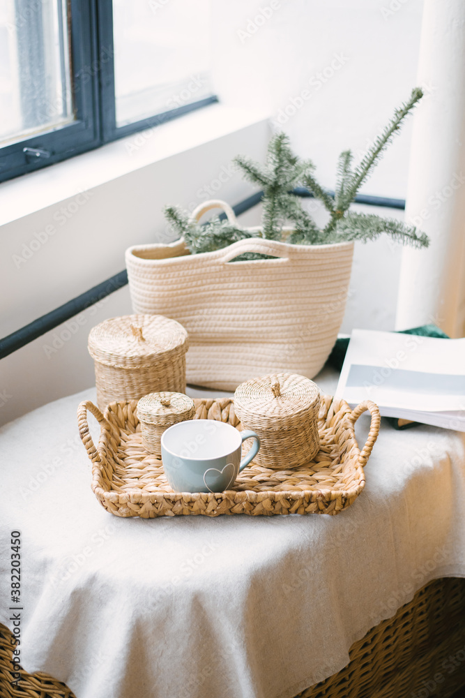 Winter Christmas decor. Mug, wicker jars, fir branches in a wicker straw bag