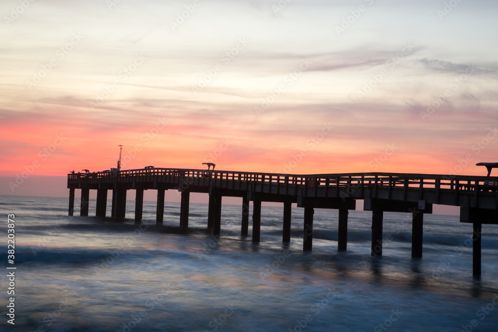 Sunrise through a fishing pier  at the beach at St Augustine, Florida.