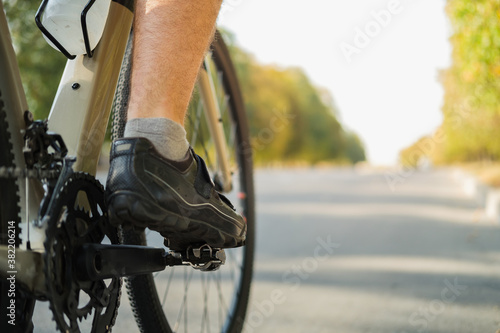 Fototapeta Naklejka Na Ścianę i Meble -  Bicycle shoes with clipless pedals on the crankset, copy space view. Cycling performance, active lifestyle, bike training concept