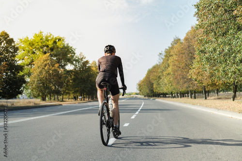 Wallpaper Mural Man on a gravel bike on the road, back view. Well equipped cyclist riding a modern bicycle outdoors Torontodigital.ca