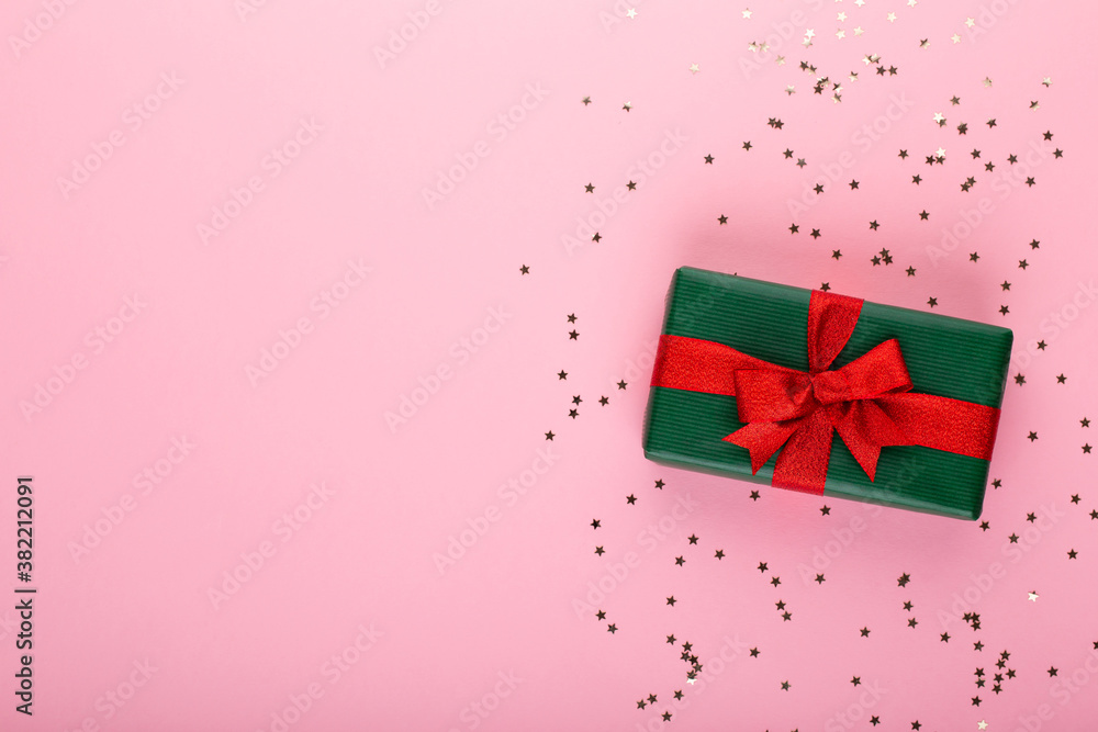 Obraz premium Gift or present box and stars confetti on color table top view. Flat lay composition for birthday, mother day or wedding.