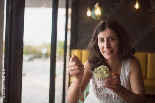 Woman eating ice cream and looking window
