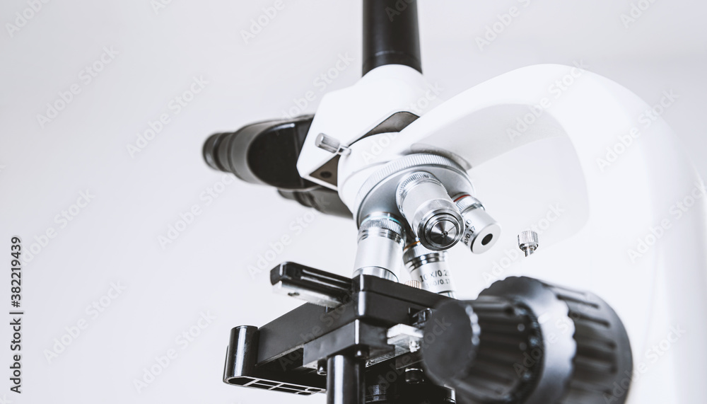 Using a biological microscope. Close-up of the microscope lens. Scientific research concept, using a microscope. Medical examinations, searching for bacteria, diseases, blood tests. Using a biological microscope. Close-up of the microscope lens. Scientific research concept, using a microscope. Medical examinations, searching for bacteria, diseases, blood tests.