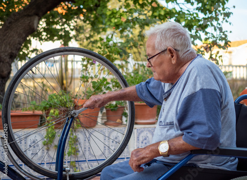 active old man fixing a bicycle outdoors © Jose R.Vazquez