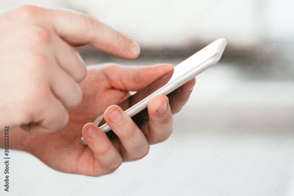 male hands holding a modern phone mock-up for your text message or information content, on the street