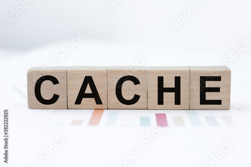 CACHE word made with building blocks located on paper charts on the table