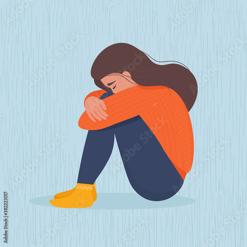 Sad depressed woman sitting hugging her knees. Vector illustration in flat style