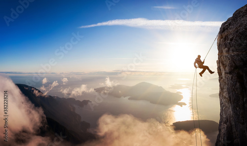 Obraz na plátne Epic Adventurous Extreme Sport Composite of Rock Climbing Man Rappelling from a Cliff