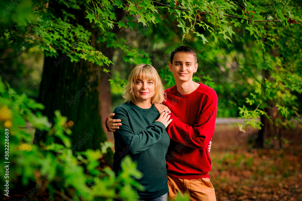 Beautiful woman,blonde,middle-aged,walking with her big son , autumn in the Park,Sunny day.