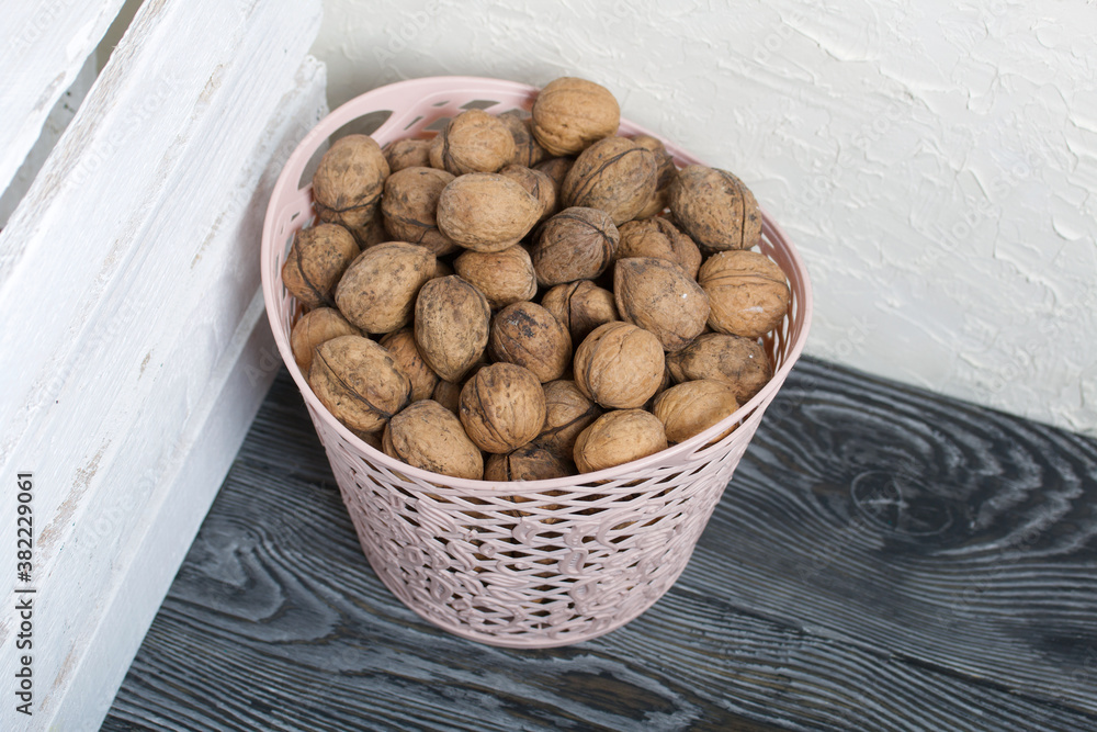 A basket with walnuts. Nearby is a white wooden box. A basket with walnuts. Nearby is a white wooden box.