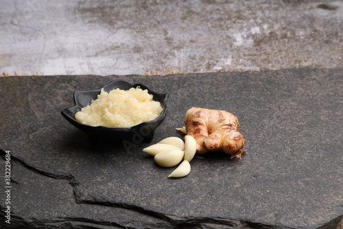 Ginger Garlic paste / Fresh mashed Adrak and Lahsun in bowl and whole. photo