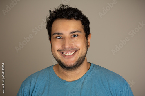 Portrait of a young man looking at the camera. Big smile and happy.