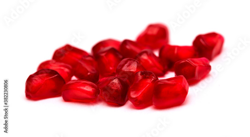 Red ripe pomegranate fruit grains on white background