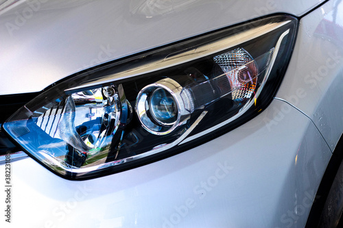 The front light of the car. Modern halogen lighting. Front lighting of a silver car © yarm_sasha