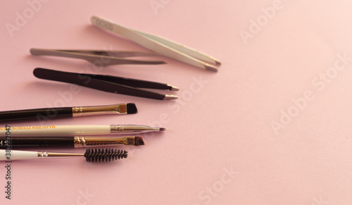 Professional set for styling eyebrows on a pink pastel background with place for text. Flat invoice composition. Makeup set. photo