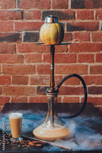 hookah tobacco concept: melon. Fresh melon with lobules. Hookah and fruits on dark with shisha smoke clouds. photo