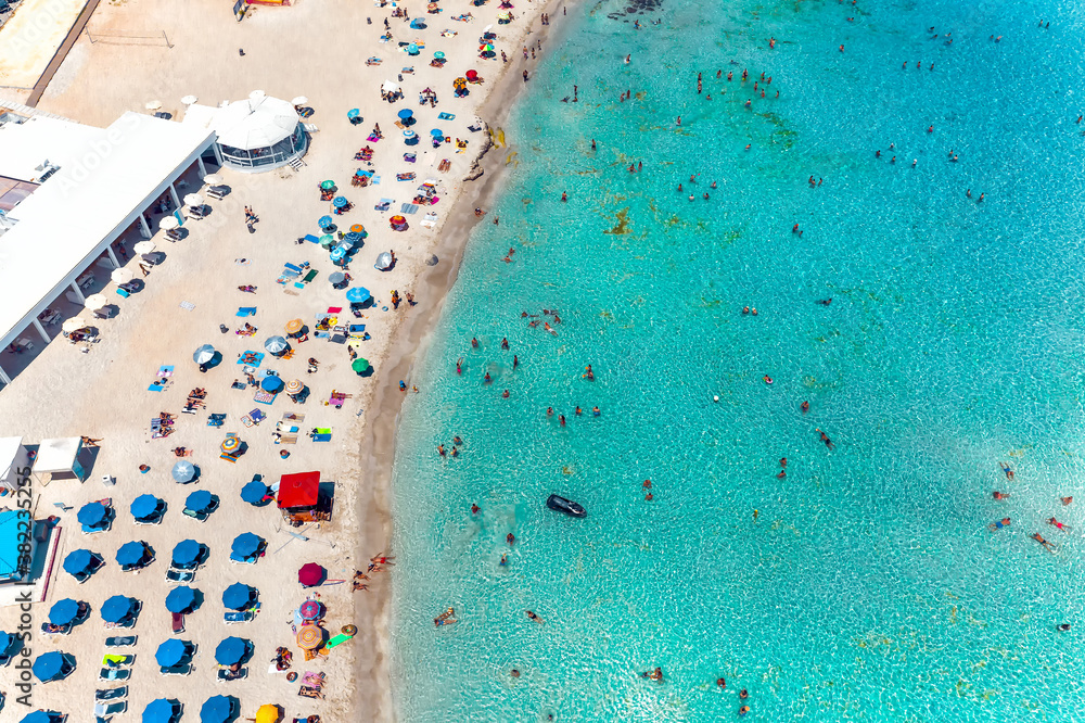 Aerial view Nissi bay beach. People, umbrellas, sand and sea wave. Famagusta District, cyprus