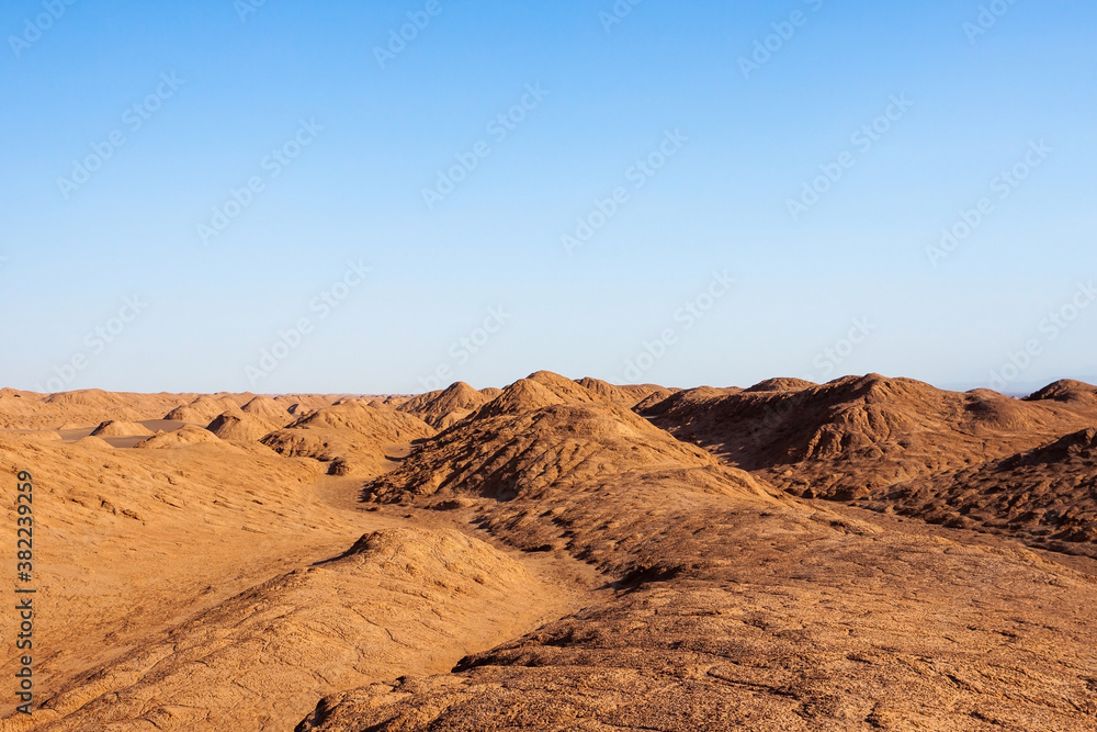 Lut desert in Iran. Sandy and rocky dunes in the Iranian desert with blue sky. Beautiful cover or background image.