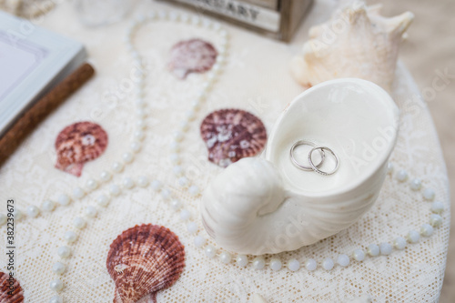 Obraz na plátně Close up view of wedding rings in the white ceramic shell on the table with wedd