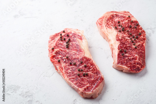 Raw Striploin beef steak on a white stone table