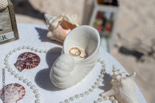 Obraz na plátně Close up view of wedding rings in the white ceramic shell on the table with wedd
