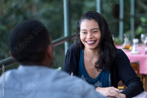 A happy multi-ethnic Latin and Black couple dining together in an al fresco restaurant, Rio de Janeiro, Brazil