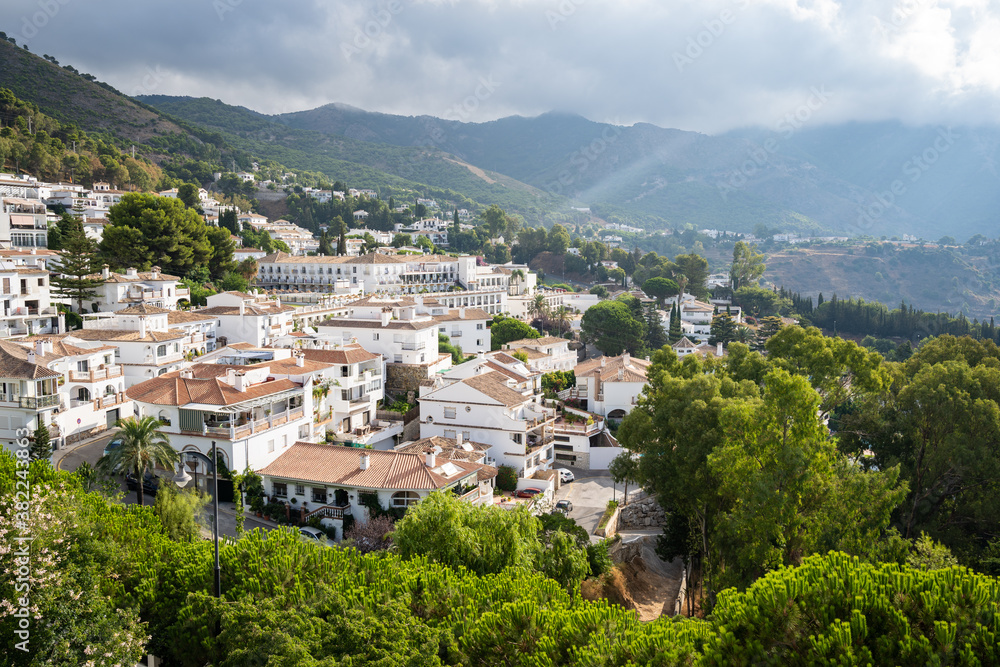 Sun rays burst through the clouds over the white washed buildings of Mijas Pueblo, Andalusia, Spain Sun rays burst through the clouds over the white washed buildings of Mijas Pueblo, Andalusia, Spain