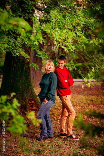 Beautiful woman blonde middle-aged with a big son walking in the Park a beautiful autumn day