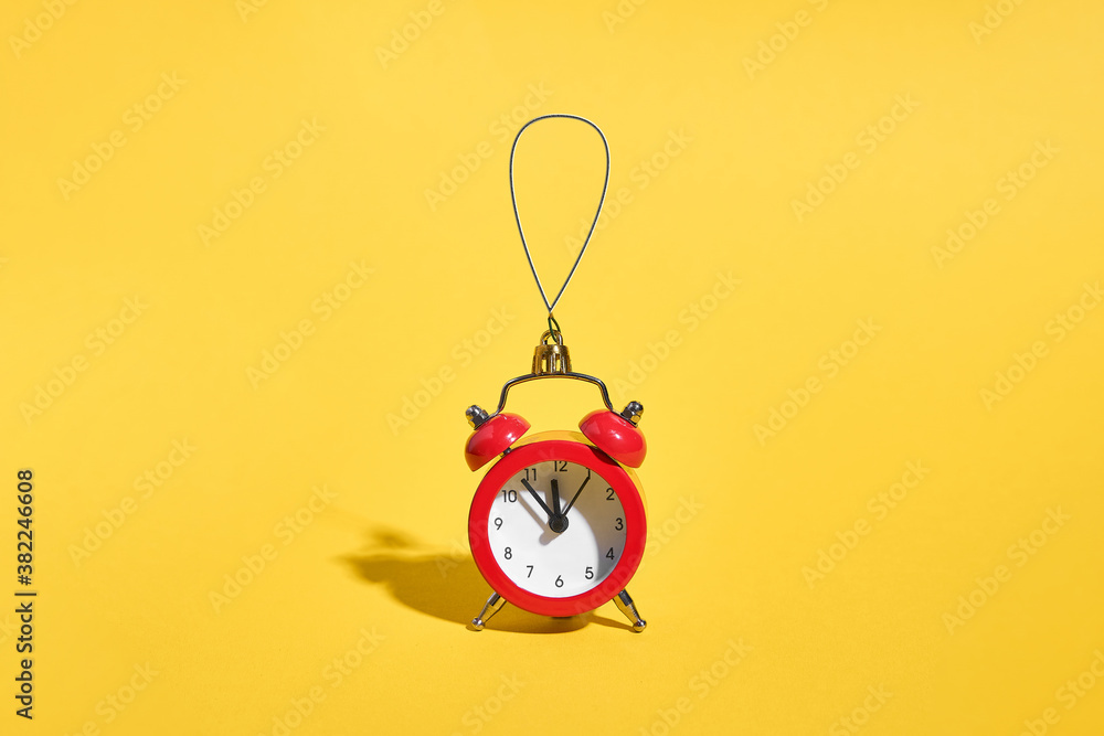 Red retro alarm clock on yellow background. Minimal time concept. Christmas or New year eve. 
