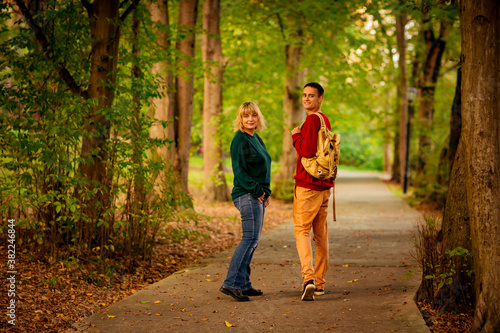 Beautiful woman,blonde,middle-aged,with a big son walking in the Park,a beautiful autumn day © khanfus