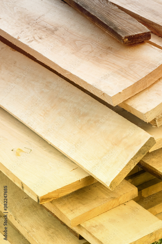 building materials pattern from a pile of pine boards light beige background