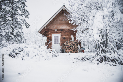 Leinwand Poster A cozy log cabin in the snowy winter landscape