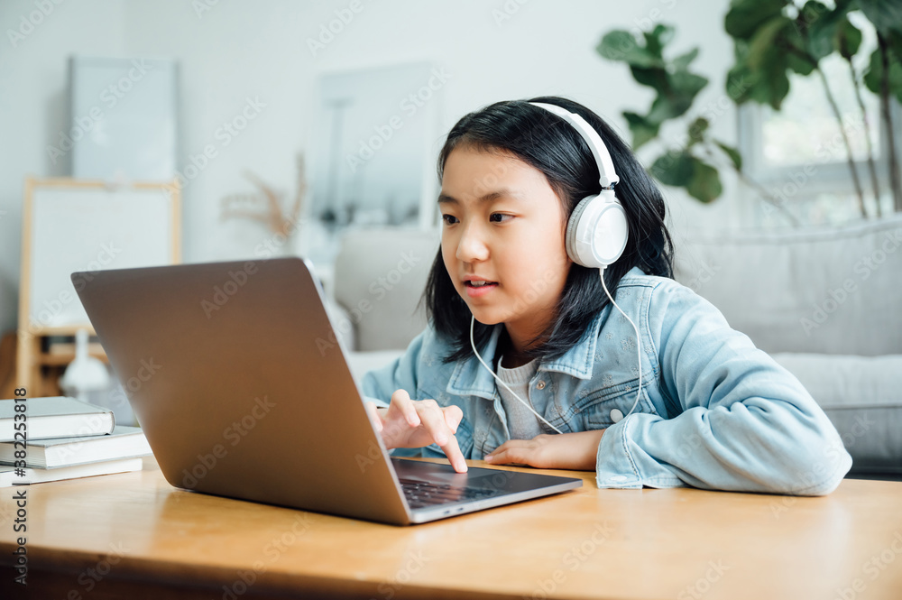 Cute teenager girl using laptop with headphones Cute teenager girl using laptop with headphones