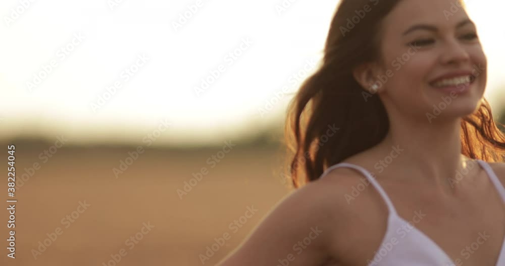 Attractive cheerful slim Caucasian woman with flying loose long dark hair running across the field. Happiness concept Attractive cheerful slim Caucasian woman with flying loose long dark hair running across the field. Happiness concept
