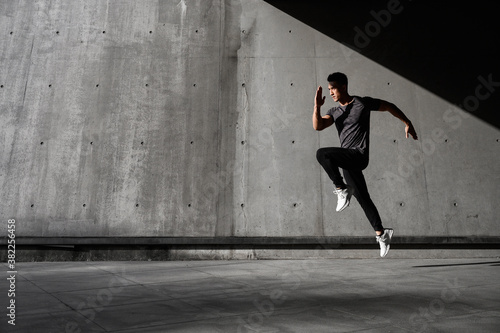 Obraz na plátně Runner practices his running skills outside with fast pace and goes for run