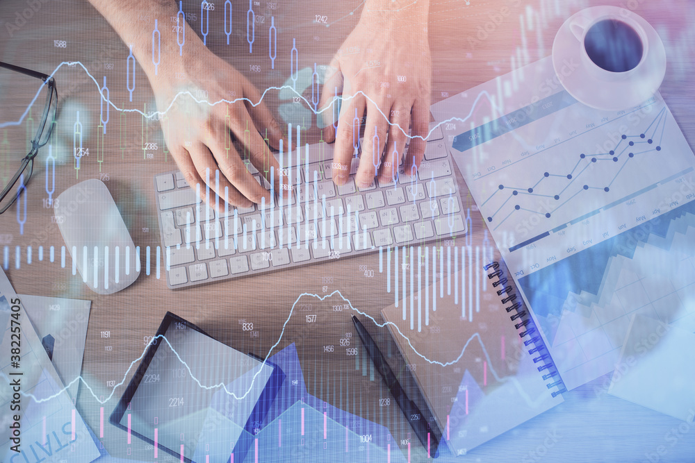 Multi exposure of man's hands typing over computer keyboard and forex graph hologram drawing. Top view. Financial markets concept. Multi exposure of man's hands typing over computer keyboard and forex graph hologram drawing. Top view. Financial markets concept.