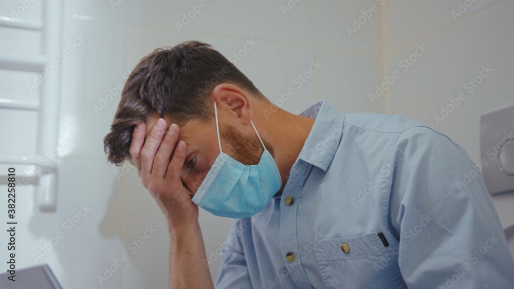 Unhappy worried businessman working on laptop wearing mask sit on the toilet at home restroom bearded wc isolation quarantine pandemic coronavirus covid-19 portrait close up slow motion Unhappy worried businessman working on laptop wearing mask sit on the toilet at home restroom bearded wc isolation quarantine pandemic coronavirus covid-19 portrait close up slow motion