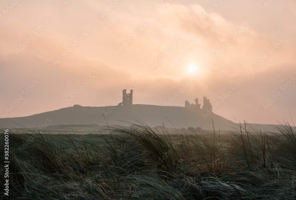 Sunrise over Dunstanburgh Castle. Northumberland, UK. Sunrise over Dunstanburgh Castle. Northumberland, UK.