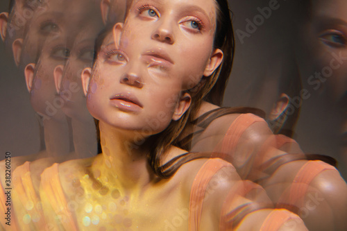 Sensual millennial woman with glitter makeup in golden light