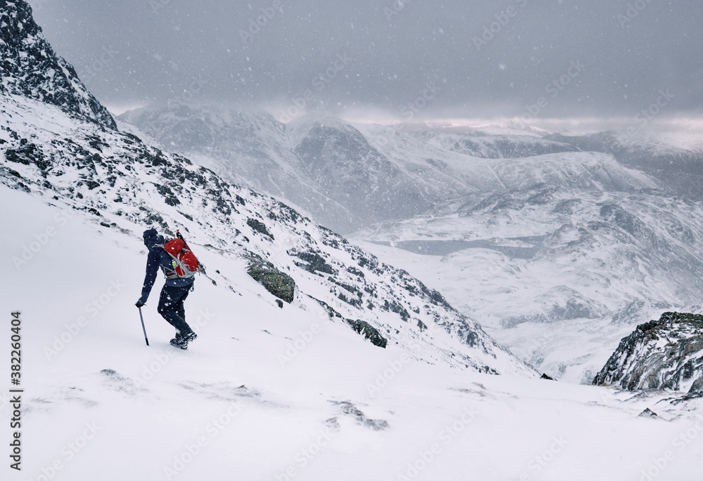 Winter mountaineer using Ice Axe and crampons below Great End. Esk Hause, Cumbria, UK. Winter mountaineer using Ice Axe and crampons below Great End. Esk Hause, Cumbria, UK.