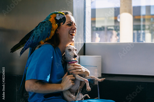 Happy vet with parrot and dog photo