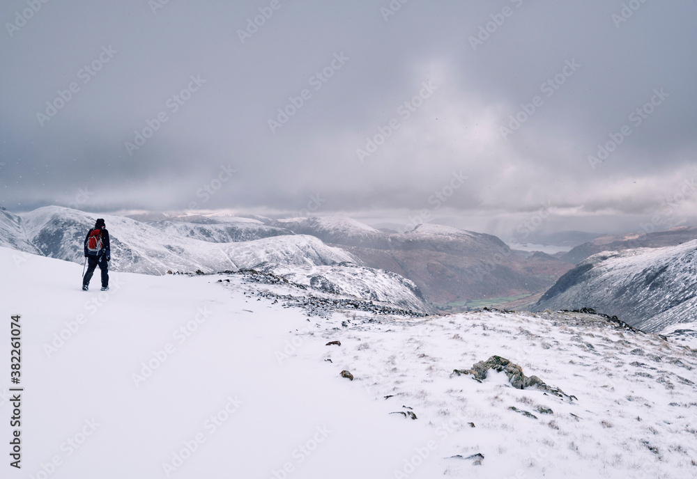 Winter mountaineer using Ice Axe and crampons below Great End. Esk Hause, Cumbria, UK. Winter mountaineer using Ice Axe and crampons below Great End. Esk Hause, Cumbria, UK.