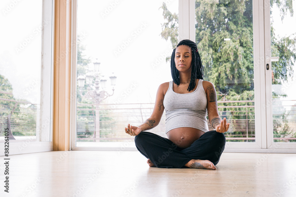 Pregnant black woman practicing yoga Pregnant black woman practicing yoga