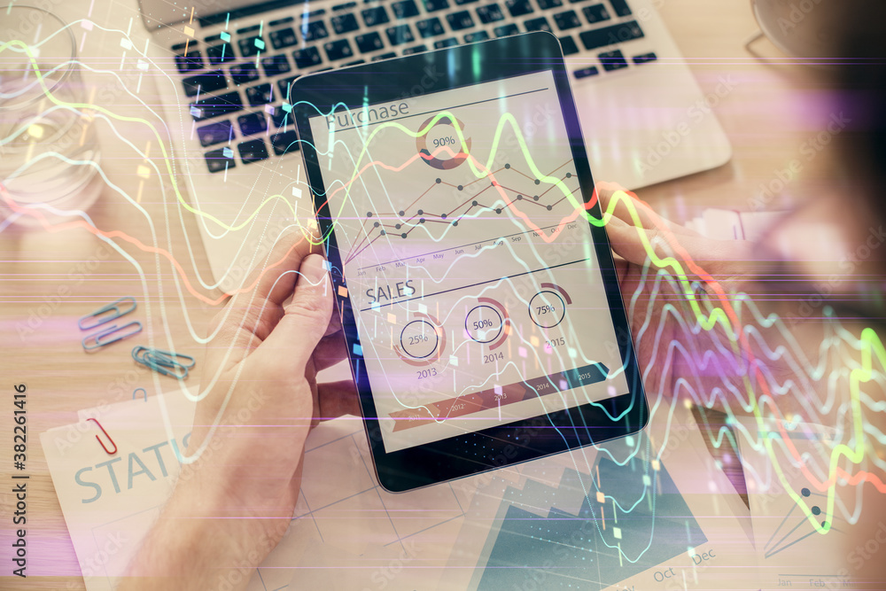 Double exposure of man's hands holding and using a digital device and forex graph drawing. Financial market concept. Double exposure of man's hands holding and using a digital device and forex graph drawing. Financial market concept.