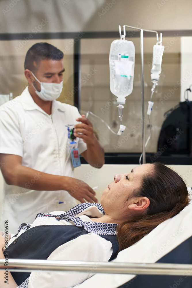 Doctor setting up IV for a female patient Doctor setting up IV for a female patient