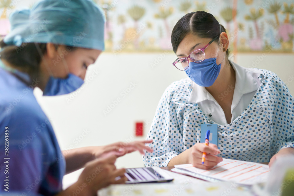 Doctor and nurse preparing documents with a tablet Doctor and nurse preparing documents with a tablet